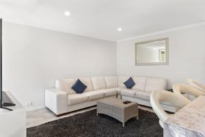 - un salon avec un canapé blanc et un miroir dans l'établissement Luxury spacious 3-bedroom Suite on exclusive Lansell Rd, Toorak, à Melbourne