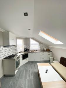 a kitchen with white cabinets and a couch and a table at One Room Studio in Râşnov +1 photo