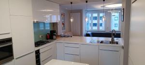 une cuisine blanche avec des armoires blanches et un évier dans l'établissement Modern appartement - Zeezicht - Perfecte ligging, à Coxyde 27 autres photos