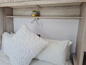 a bedroom with a white bed with a wooden headboard at Mews Road Self-Catering in Queenstown