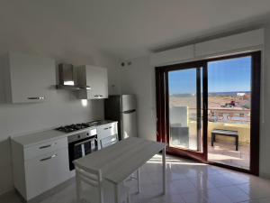 a kitchen with a table and a window with a view at Casa di Jack I.U.N. R6217 in Quartu SantʼElena