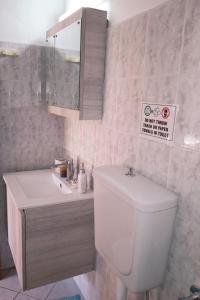 a bathroom with a toilet and a sink and a sign at FLOWERS STUDIOS in Skala