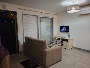 sala de estar con sofá y TV en Villas Floryanne - bassin arcachon en Audenge
