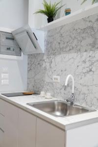 a kitchen with a sink and a white counter top at Oyster Apartments in Sarandë