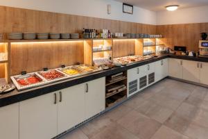 a kitchen with a buffet of food at Hotel Regent in Třeboň