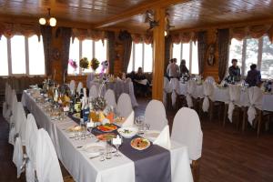 a dining room with white tables and white chairs at Baza Otdykha Ivolga in Ulyanovsk