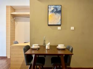 a dining room table with chairs and a painting on the wall at Hush Inn at K Avenue Kota Kinabalu in Kota Kinabalu