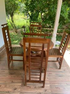 una mesa de madera y sillas en un porche en Hotel Gimanhala Thisawewa, en Anuradhapura