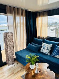 a living room with a blue couch and a table at Premium Hausboot Blaue Lagune in Lübeck