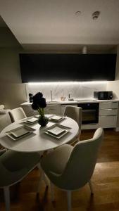 uma cozinha com uma mesa branca com cadeiras e uma mesa de centro em Diamond of Skopje Luxury apartment 18th floor em Skopje