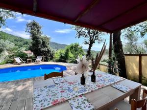 stół z kwiatami obok basenu w obiekcie Ganzo - Tuscany Retreat w mieście Massarosa