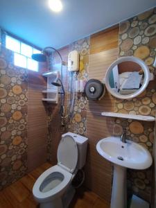 La salle de bains est pourvue de toilettes, d'un lavabo et d'un miroir. dans l'établissement Ruenthip Homestay, à Bangkok