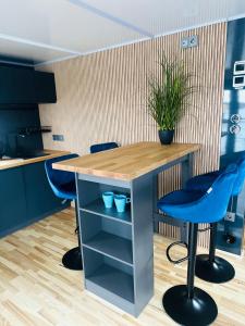 a kitchen with a table and two blue stools at Premium Hausboot Blaue Lagune in Lübeck