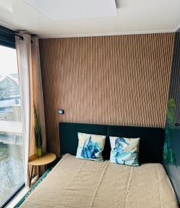 a bedroom with a bed with a striped wall at Premium Hausboot Blaue Lagune in Lübeck
