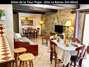un soggiorno con tavolo, sedie e TV di Les Gîtes de la Tour Pujol ad Argelès-sur-Mer