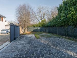einen steinernen Gehweg mit einem Zaun im Hof in der Unterkunft House Sabbioneta in Sabbioneta