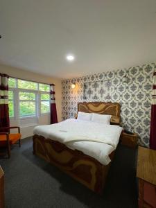 Un dormitorio con una cama grande y una ventana en Heritage Rose Inn, en Srinagar
