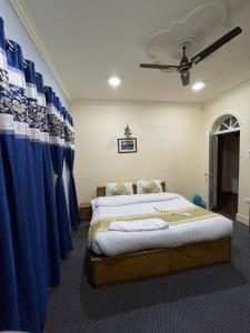 a bedroom with two beds and a blue curtain at Heritage Rose Inn in Srinagar