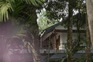a white house with a balcony and trees at Marari Bobans villa in Mararikulam