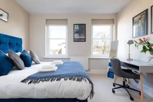 una camera con letto blu e bianco e scrivania di Central, Stunning 2 Bed Apartment with Parking! a Cambridge