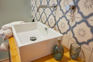 a white sink in a bathroom with a wall at House on the sea garden in Marsala +24 photos
