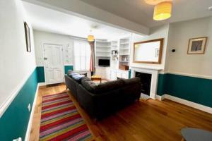 a living room with a couch and a fireplace at Charming 1 bed super central Terraced House in Cambridge