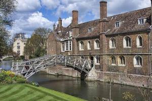 a bridge over a river in front of a building at Charming 1 bed super central Terraced House in Cambridge