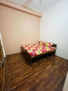 1 dormitorio con 1 cama en una habitación con suelo de madera en Ashu Homestay, en Ayodhya