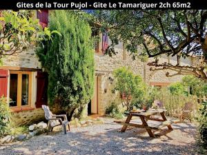un tavolo da picnic di fronte a un edificio in pietra di Les Gîtes de la Tour Pujol ad Argelès-sur-Mer