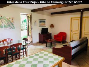 un soggiorno con tavolo, sedie e TV di Les Gîtes de la Tour Pujol ad Argelès-sur-Mer