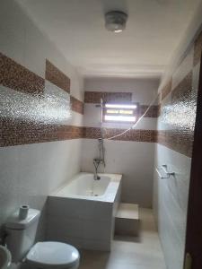 ein Badezimmer mit einer Badewanne, einem WC und einem Waschbecken in der Unterkunft Residence Hadja 03 in Dakar