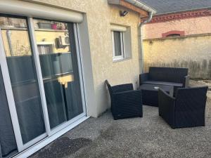 eine Terrasse mit zwei Stühlen und einer Couch neben einem Fenster in der Unterkunft Villa chaleureuse Centre ville - Parking privée in Gap