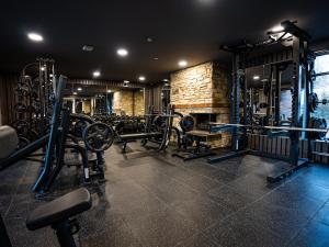 uma sala de fitness com um ginásio com pesos e equipamento em Hotel We Wellness em Adendorf