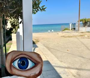 a statue of an eye on a pole next to the beach at House by the sea suite 2 in Skála Foúrkas