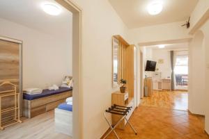 een kamer met een bed en een stoel. bij Apartment Tara in Njivice
