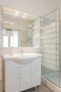 een witte badkamer met een wastafel en een douche bij Apartment Tara in Njivice