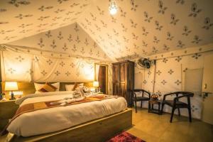 Luxury The Sunrise Resort with swimming pool Jaisalmer في جيلسامر: غرفة نوم بسرير كبير مع مظلة