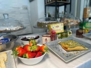 une table avec des fraises et une plaque de nourriture dans l'établissement BB 10 Serpotta & Restaurant, à Palerme