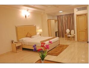 a bedroom with a bed and flowers in a room at Hotel Galaxy Grand, Lucknow in Lucknow