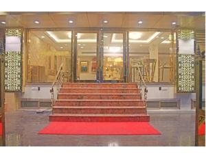 a set of stairs with a red rug in a building at Hotel Galaxy Grand, Lucknow in Lucknow