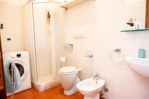 a bathroom with a toilet and a sink and a washing machine at Ferrara center - Luxury apartment in medieval area with Wi-Fi in Ferrara