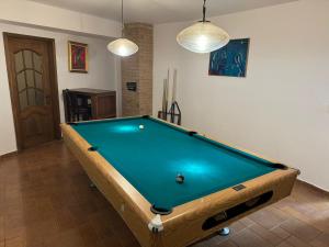 a pool table in a living room with two lights at Evie's Tree House in Dragomirna