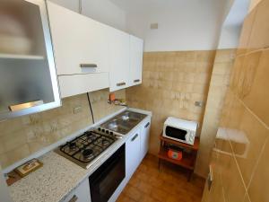 a small kitchen with a stove and a microwave at Appartamento da Davide in Pieve Di Ledro