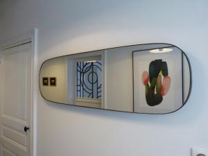 un espejo colgando de una pared con un cactus en Chambres d'hôtes Les Pergolas, en Marcigny