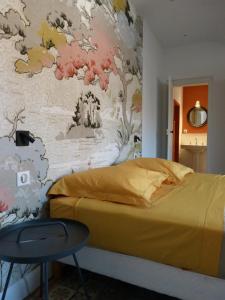 1 dormitorio con 1 cama y una pared con un mural en Chambres d'hôtes Les Pergolas, en Marcigny