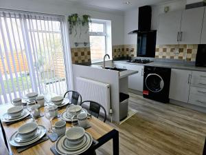 a kitchen with a table with plates and dishes on it at Walderslade Serviced Accommodation Medway Maidstone in Kent