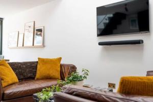 a living room with a couch and a flat screen tv at Stylish Cambridge Home with free parking in Cambridge