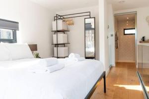 a bedroom with a white bed and a mirror at Stylish Cambridge Home with free parking in Cambridge