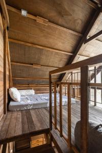 a room with two beds on a wooden floor at Bali Cozy Bungalows, Nusa Dua Benoa in Nusa Dua