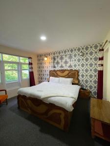 um quarto com uma cama grande e uma janela em Heritage Rose Inn em Srinagar